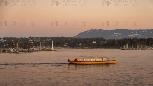 A vibrant yellow boat glides across the serene waters of Lake Geneva during a stunning sunset, with