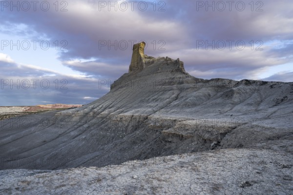A stunning view of a uniquely shaped rock formation amid textured desert terrain in Utah, captured