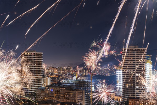 Captivating night view of Tbilisi's downtown skyline illuminated by vibrant fireworks. The urban