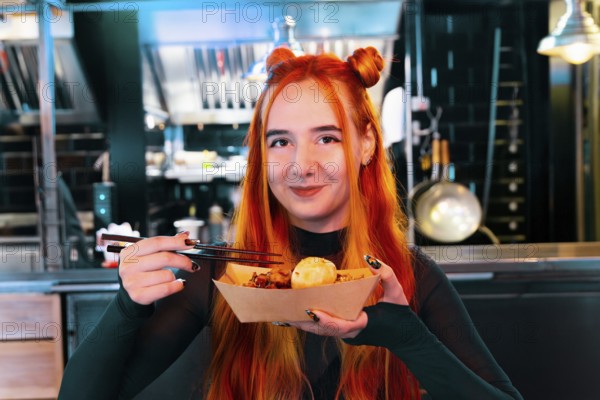 A woman with red hair delights in Asian street food at a lively market She holds chopsticks and a
