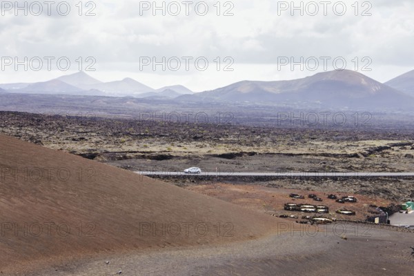 Deserted road in a volcanic landscape. The arid terrain and mountains on the horizon highlight the