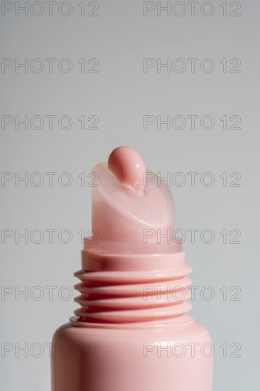 Close-up view of a pink lip balm on pink tube against a neutral background. This image showcases
