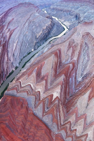 An aerial photograph captures the stunning Rio San Juan as it snakes through the vivid red and grey