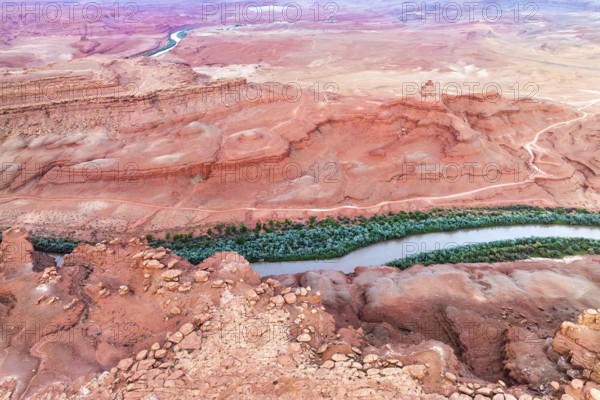 Aerial shot captures the serpentine Rio San Juan cutting through the vibrant red desert landscape