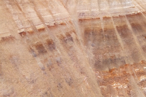 Aerial view of a multicolored sandstone exhibiting unique textures and earthy hues. The striations