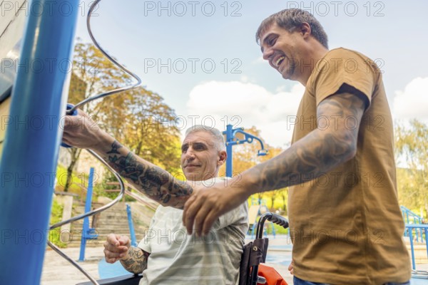 Two friends, one in a wheelchair by cerebral palsy, enjoy a sunny day at an inclusive park,