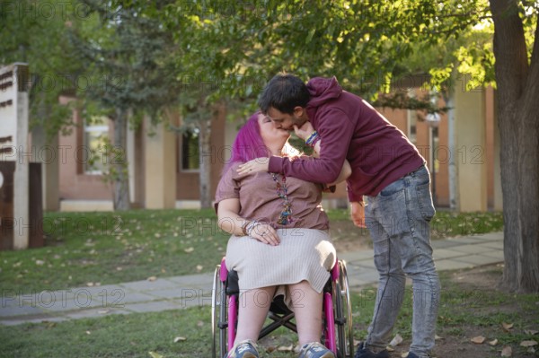 A couple shares an affectionate kiss on a peaceful college campus The woman, with pink hair and