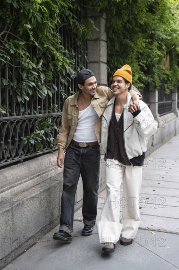 A joyful gay couple strolls arm in arm along a leafy city sidewalk, sharing smiles and enjoying