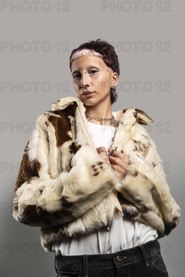 A woman with distinctive makeup and jewelry poses confidently in a stylish faux fur coat. The