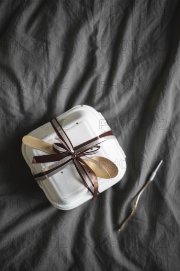 Top view of an elegantly presented bento birthday cake, securely packaged in a white takeout box