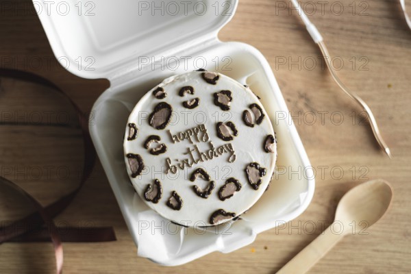 Top view of a stylish Bento birthday cake decorated with heart-shaped toppings, presented in a