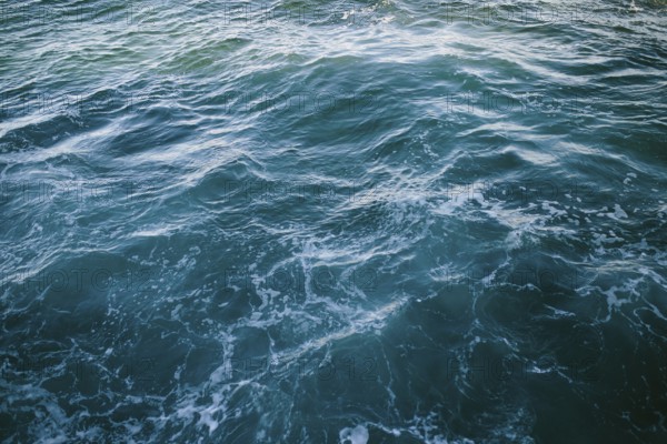 Close-up of dynamic ocean waves with swirling patterns and frothy textures at Flatrock,