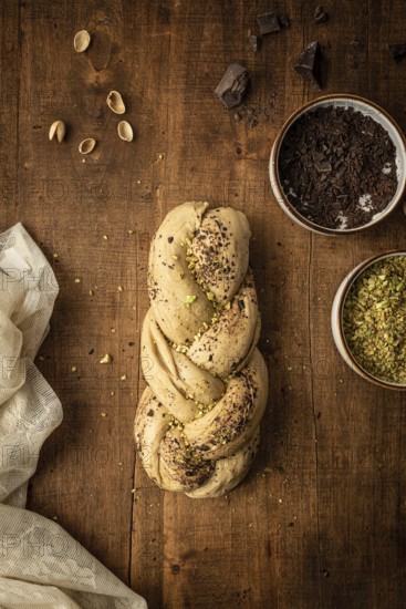 Top view of a freshly baked Bakbah bread adorned with chocolate shavings and pistachio bits, placed