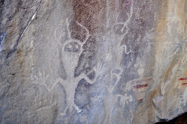Prehistoric rock carvings, petroglyphs from the Fremont culture, of human-like figures on a rock,