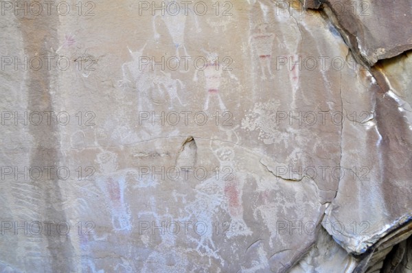 Ancient rock art, petroglyphs from the Fremont culture with human figures in shades of red and