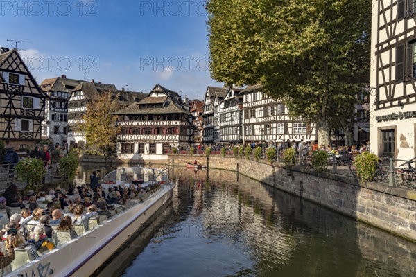 Sightseeing boat, half-timbered houses and the Maison des Tanneurs on the river Ill in Petite