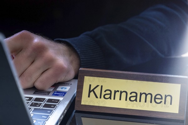 Clear name requirement Symbolic image: Brass sign with (digitally added) text KLARNAMEN next to a