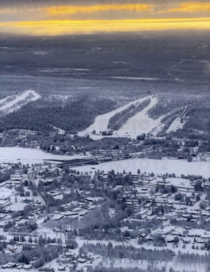 View of the snowy town of Rovaniemi with the Kemijoki river, at sunrise, in winter, aerial view,