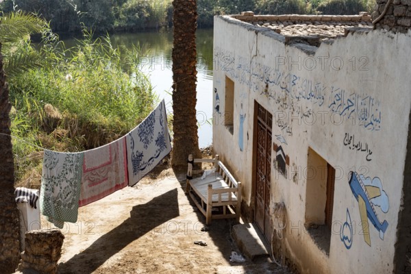 Luxor, Egypt. 13th December 2020 Typical Nile side house with painted Haj pilgrimage murals in a
