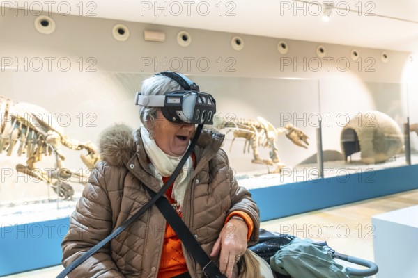 Senior woman wearing a vr headset with an open mouthed, delighted expression experiencing immersive