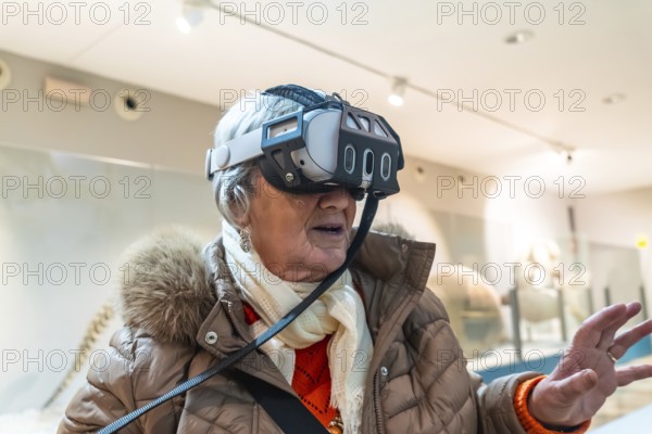 Senior woman wearing a vr headset, exploring immersive digital content and interactive exhibits in