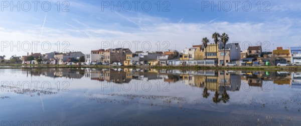Traditional houses of el palmar fishing village reflecting perfectly on the calm water surface of