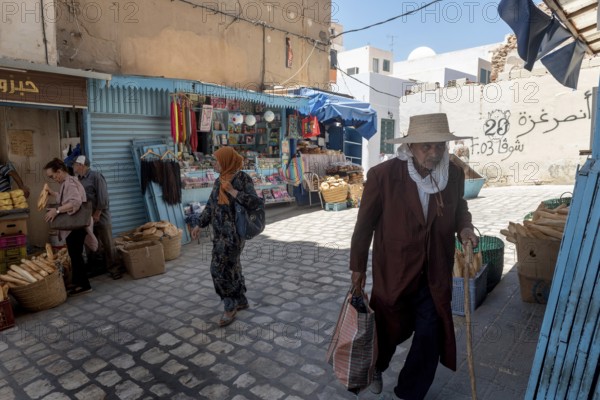 Male and female Tunisians shopping for bread in the market of Sfax Medina, Tunisia, North Africa
