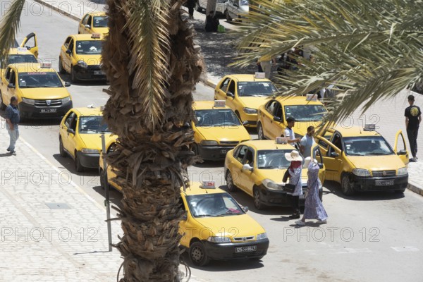 Streets of Sfax busy with taxi cabs waiting outside ancient fortified gate of Sfax Medina, known as