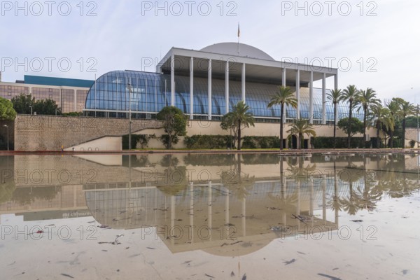 The palau de la musica music hall in valencia, spain, reflecting in a large permanent water feature