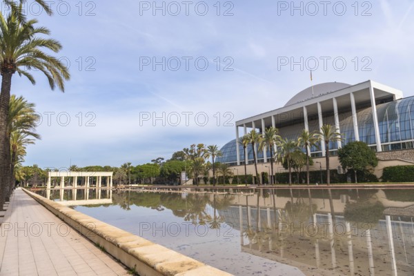 Palau de la musica building, an iconic landmark in valencia, reflecting in the turia gardens' calm
