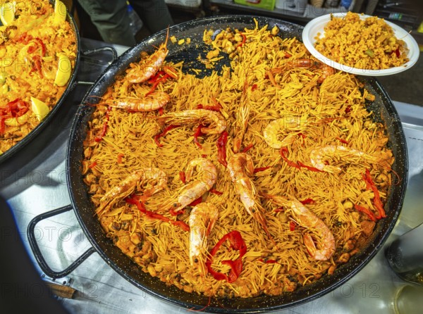Large paella pan presenting fideua, a traditional spanish noodle dish from valencia, prepared with