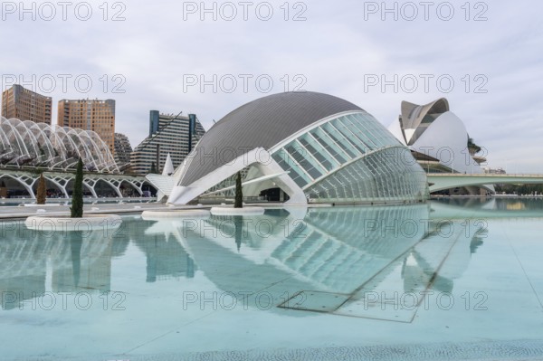 Hemisferic building reflecting in turquoise lagoon at the city of arts and sciences in valencia,