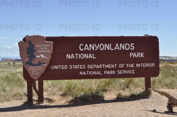 Sign for Canyonlands National Park in a desert landscape under clear skies, Canyonlands National