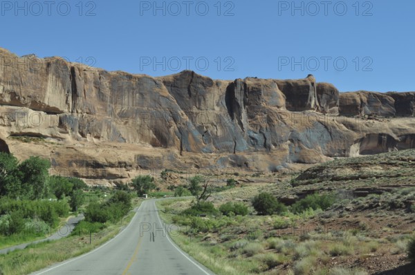 Road leads through an impressive desert landscape with high rock walls, Canyonlands National Park,