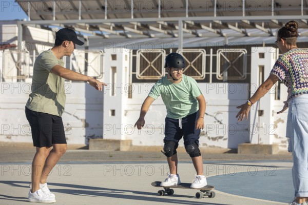 Down syndrome teenager skateboarding with encouragement and support from family members Empowering