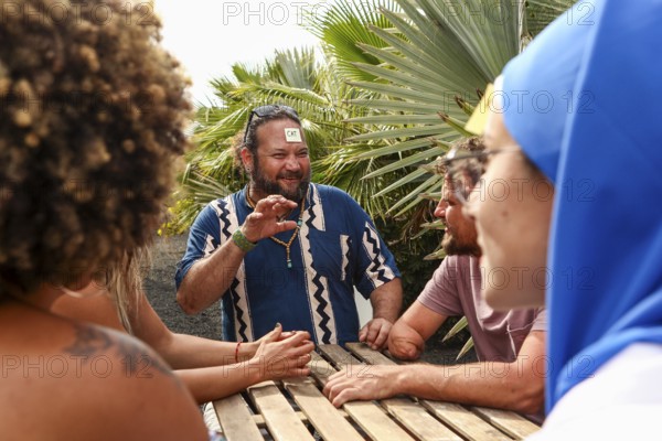 A group of friends enjoys a fun and lively conversation while playing a game outdoors, surrounded