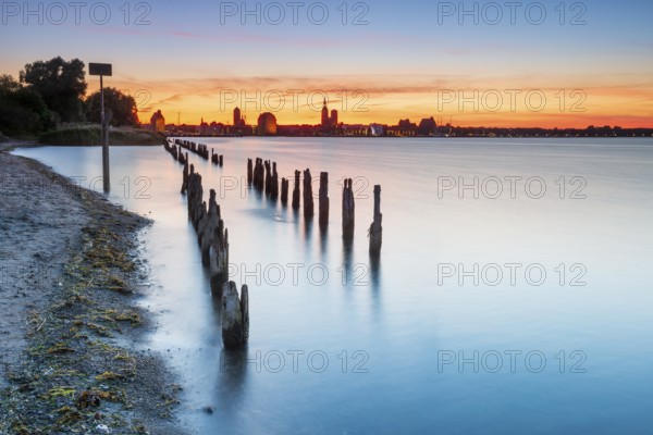 View at sunset over the Strelasund of the illuminated silhouette of the city of Stralsund with its