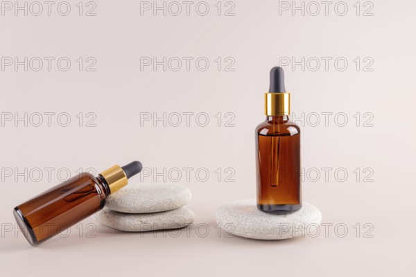 Two amber glass dropper bottles on smooth stones, featuring a minimalist aesthetic Ideal for