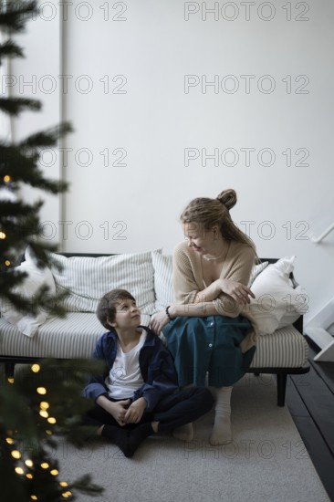 A warm holiday moment, a mother and child share smiles in a cozy living room with festive decor A