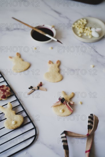 Top view of freshly baked Easter bunny cookies decorated with hibiscus tea paint, displayed on a