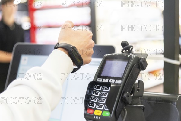 Cropped image of woman's hand making a payment using a smartwatch at a card terminal in a