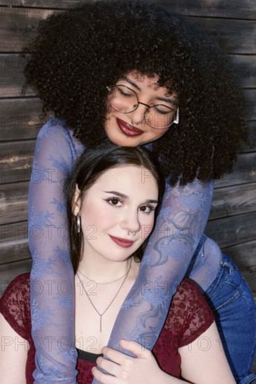 Two multiethnic Gen Z women sharing a close embrace, displaying friendship and joy. The Hispanic