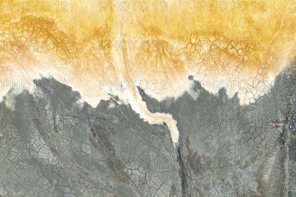 Captivating multicolored mud texture showcasing vibrant orange and gray hues The cracked surface
