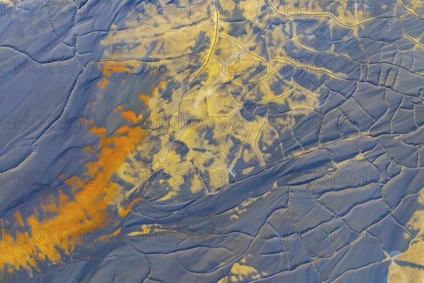 Aerial view of multicolor mud formations showcasing vibrant patterns and textures Shades of orange