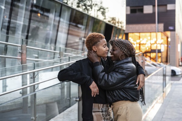 An affectionate LGBT multiethnic couple embraces outdoors in the city, capturing a candid and