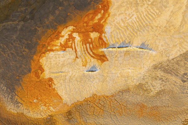 Aerial view of vibrant multicolor mud patterns showcasing orange, brown, and earthy hues The
