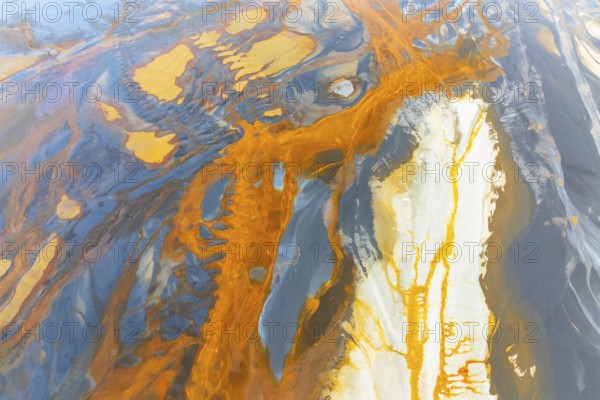 An intricate display of vibrant, swirling abstract textures featuring a dynamic blend of orange,