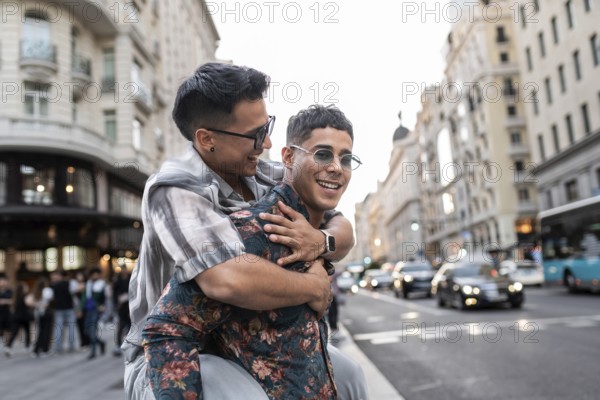 A latin gay couple shares a joyful moment on a bustling street in Madrid, surrounded by beautiful