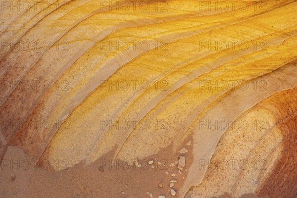 Close-up view of golden desert sandstone with natural striped patterns and textures in yellow and