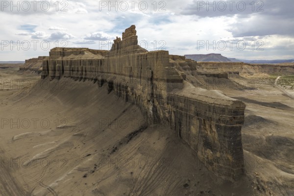 A dramatic aerial view of Caineville Mesa, Utah, showcasing towering rock formations and expansive